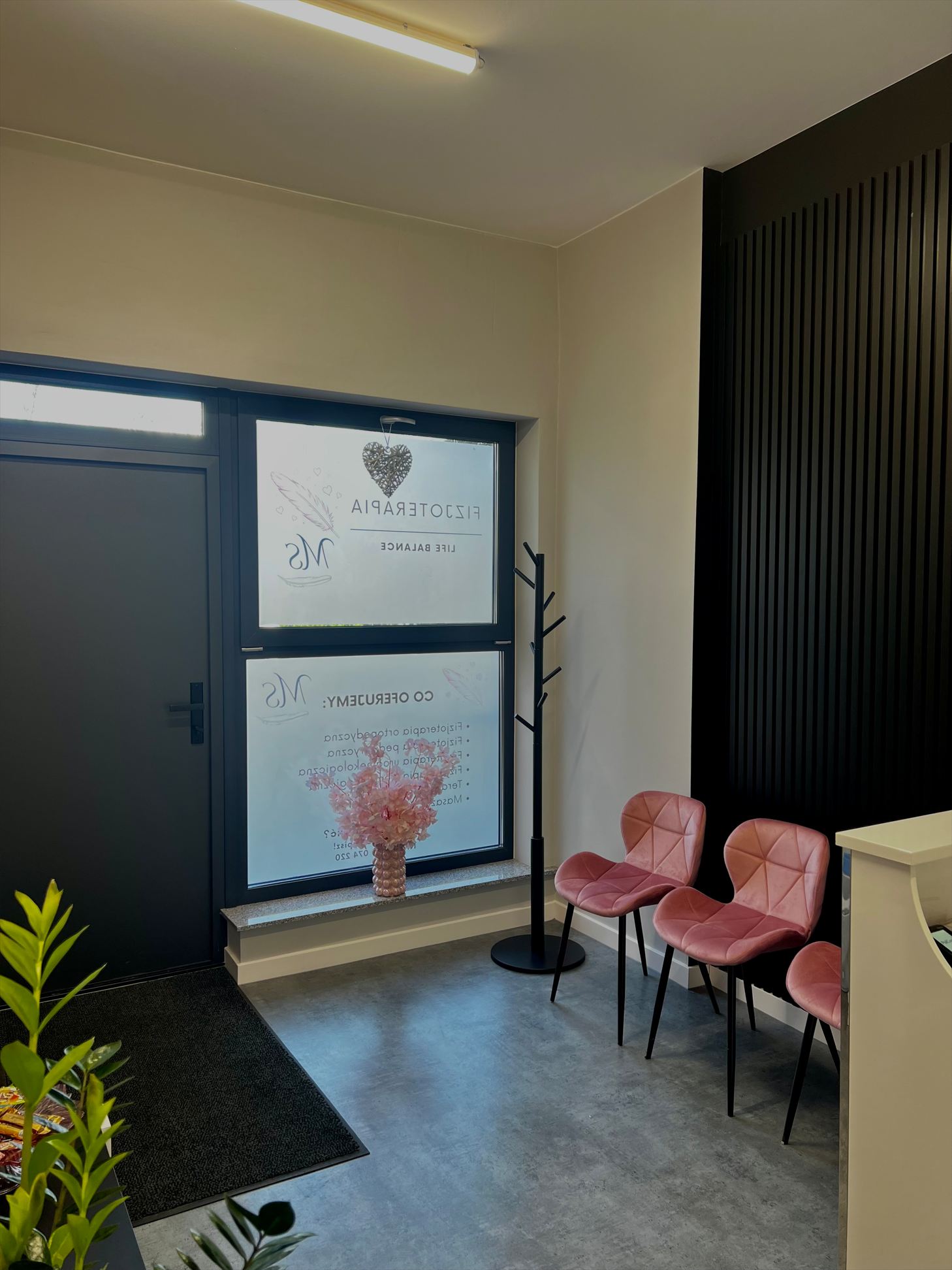 Strefa wejściowa i poczekalnia z różowymi krzesłami